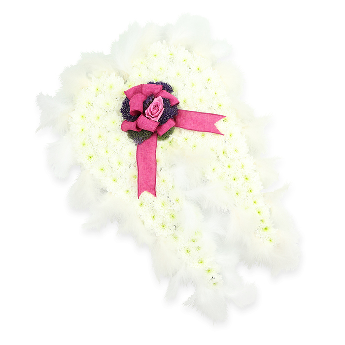 A serene angel-wing floral tribute is shown against a crisp white background, designed to bring a sense of gentle guardianship to a farewell in Stanmore. The wings are constructed from a thick layer of white spray chrysanthemums, each petite flower meticulously placed so that they create a plush, cushion-like surface that looks impossibly soft to the touch. The delicate petals overlap in tight clusters, while the faint green centres add depth and a hint of freshness to the otherwise snowy composition. Running along the outline of the wings is a border of feathery white plumage, each feather light and airy, echoing the graceful arc of the wings and adding an ethereal shimmer as they catch the light. Where the wings meet, a striking fuchsia-pink satin ribbon has been shaped into an opulent bow, its glossy loops and trailing tails providing a vibrant contrast to the tranquil whites. Nestled in the centre of this bow is a single pink rosebud, its petals still partially closed, suggesting a love that remains protected and cherished. Just beneath, a group of deep purple thistle-like flowers or textured foliage peeks through, offering a rich, sombre undertone that balances the overall softness of the piece. The tribute feels contemplative and comforting, the kind of arrangement chosen by families in Stanmore who want something both symbolic and deeply personal for a funeral or memorial service. It could rest gracefully by the casket or at the front of a chapel, created by a local florist who understands how flowers can carry stories of a life well lived.