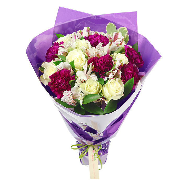 Set against a bright white background, this elegant hand-tied bouquet reveals every nuance of colour and texture, as though it has just been lifted from the workbench at a Stanmore florist. At its centre, cream-white roses with gently layered petals provide a calm, timeless focal point, their soft curves hinting at a subtle, classic fragrance. Surrounding them, generous clusters of deep magenta or fuchsia carnations bring vibrancy and depth, each ruffled bloom rich with texture that suggests plushness and movement. Woven among these are white alstroemeria, or Peruvian lilies, their slender, elongated petals adorned with delicate pinkish-red streaks and centred with dark stamens, adding fine, almost brushstroke-like detail to the composition. Fresh green foliage, including a few variegated leaves shaded with pale cream, wraps around the flowers to create a round, full silhouette, evoking the feel of well-tended gardens dotted through Stanmore's quiet residential streets. The stems gather into a narrow, tapered bundle at the base, and are embraced by an inner collar of crisp white floral paper that sits snugly beneath the flowers, providing a clean, structured frame. Over this white layer, a translucent sheet of crinkled purple cellophane or paper forms an outer wrap, its surface catching light in soft highlights and shadows, lending the bouquet a subtle sense of luxury and celebration. At the very base, a bright lime-green satin ribbon is tied into a small, cheerful bow, its iridescent gleam adding a playful note. From this bow hangs a small, pale brown rectangular gift tag, left blank to carry a personal sentiment for birthdays, anniversaries, thank-yous, or get-well wishes. Altogether, the bouquet exudes warmth and elegance, making it ideal for same-day flower delivery around Stanmore, from Canons Park to Stanmore Hill.