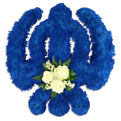 This image presents a beautifully realised Khanda floral arrangement, a traditional Sikh emblem interpreted with meticulous floristry. Set against a pure white background, the Khanda form seems to float, its silhouette traced in a rich sweep of royal blue chrysanthemums. Each tiny floret is packed closely to the next, creating a dense, sculptural texture that defines the chakkar ring, the upright central sword, and the twin kirpans with remarkable clarity. The blue hue is deep and contemplative, similar to the stillness of an early evening sky over Stanmore Country Park, and it envelops the tribute with a sense of spiritual depth and quiet strength. Anchoring the composition near the base of the central sword is a small, contrasting cluster of white and green. Three ivory-white roses, their petals gently layered, rest among delicate clouds of baby's breath and other tiny white fillers, all framed by smooth, dark green leaves that add structure and natural freshness. This soft heart of white within the blue suggests purity, comfort, and the hope of peace for the departed soul. The lighting is gentle, casting slight shadows that reveal thickness and height in the flowers without distracting from their serenity. The overall effect is that of a thoughtful, reverent tribute such as Flowers Stanmore might prepare for delivery to local gurdwaras, funeral homes, or family addresses. It speaks not just of loss, but of enduring faith and the bonds of community, providing a meaningful floral expression for Sikh families marking a farewell or remembrance in Stanmore and the surrounding area.