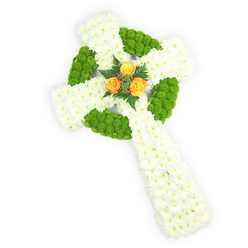 Seen from just above, this three-dimensional Celtic cross is assembled entirely from fresh blooms and presented against a crisp white backdrop that focuses attention on form and colour. The primary body is a plush field of small white spray chrysanthemums, packed tightly to read as soft, dignified massing; their delicate, papery petals give a sense of serene purity and calm. Contrasting sections of bright apple-green button chrysanthemums are worked into the design to outline the central circular ring and to create alternating blocks along the cross arms, their rounded, button-like texture creating a tactile counterpoint to the airy white. Centered where the arms meet, three fully opened orange-yellow roses form a small, luminous heart, their warm tones drawing the eye and offering a comforting point of light within the composed arrangement. Dark green foliage, likely fern or similar fine-leaved greenery, nestles briefly around the roses to lift them and provide depth. Soft studio lighting highlights the intricacy of the petal edges and the three-dimensionality of the construction without harsh glare. The choices of white, green, and orange-yellow subtly call to Irish symbolism and to the Celtic cross iconography, making this a meaningful sympathy or funeral piece for families around Canons Park, Stanmore Broadway, or the wider Harrow area. The overall effect is respectful, crafted for remembrance, and reflects the precise hand of a florist experienced with memorial work in the local community.