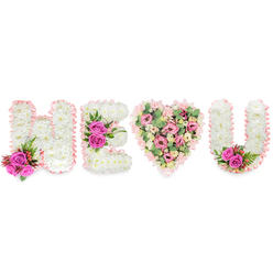 Presented on a brilliant white field, this floral composition spells H, E, a heart and U with the kind of measured detail clients in Stanmore expect from an experienced florist. The three letters are formed from tight clusters of creamy-white chrysanthemums, their minutely textured surfaces catching soft overhead light and framed with a pale blush satin ribbon that gives each character a ribboned halo. The central heart diverges into a gentler palette: layers of soft pink carnations and delicate blush lisianthus or small roses, punctuated by pale eucalyptus leaves that breathe green into the pink fields and add a subtle aromatic note. Vibrant fuchsia roses appear as deliberate highlights - a compact accent at the lower arm of the H, a central trio on the E, and a final pair tucked into the inside curve of the U - each bolstered by small red-tinged berries and filigree-like deep green foliage that recalls fern or asparagus leaf for contrast and structure. The arrangement's mood is tender and reverent, equally suited to a celebration of enduring affection or a thoughtfully personalised memorial. Lighting is neutral and bright, ensuring the whites read as pure and the pinks retain their warmth. The satin ribbon edges and the mix of textures - soft carnations, sturdy chrysanthemums, glossy roses, and airy eucalyptus - create an overall balance between formality and intimacy. For local families, this is an arrangement we commonly prepare for services near Bentley Priory or for delivery to addresses around Stanmore Broadway; Flowers Stanmore can adapt the scale and accents to fit a chapel or family home.