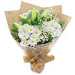 A classic hand-tied bouquet of white flowers, described as if set on the counter of a small Stanmore shop under soft morning light. The arrangement gathers abundant white daisy-like chrysanthemums with bright yellow centers, their many fine petals forming cheerful, cushion-like heads that sit low and rounded through the middle of the bouquet. Above and around them, a handful of graceful white lily stems rise-the majority still in elongated greenish buds that promise future bloom, while a couple are beginning to open, their broad petals suggesting a gentle, quiet drama. Sprigs of airy baby's breath (Gypsophila) float between the larger blooms like soft clouds, giving the composition a light, breathy texture and quiet movement. Rich, glossy dark green leaves and stems frame the flowers, lending depth and a fresh, garden-scented contrast to the crisp whites. The bouquet is wrapped in rustic, crinkled brown kraft paper with a protective outer layer of clear cellophane that catches the light, and the base is neatly gathered and tied with natural twine, forming a tidy, portable stand. Holding the piece, you would notice a subtle, clean fragrance-green, slightly sweet, the faint perfume of lilies yet to open and the dry whisper of paper. This design reads as tranquil and sincere, suitable for comforting sympathy gestures, understated congratulations, or an elegant get-well offering. Locally, this style echoes the modest, thoughtful bouquets often chosen by Stanmore residents sending flowers to friends near Stanmore Broadway, Bentley Priory, or the nearby tube station, where simplicity and care are most appreciated.