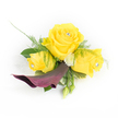 A petite, handcrafted corsage captured against a clean white backdrop, where three sunlit yellow roses take centre stage, each petal velvety and warmly saturated like a Stanmore summer afternoon. The largest rose opens fully in the middle, balanced by two slightly smaller, half-open roses either side; each has a tiny clear rhinestone nestled at its heart, catching light and adding a discreet, sparkling note to the composition. Just beneath this trio a single, sculptural calla lily in a deep plum or burgundy curves downwards and left, its satin-like throat and dramatic silhouette providing a rich, moody counterpoint to the luminous yellows. Wisps of asparagus fern thread through the arrangement, their feathery texture softening the edges, while broader dark green leaves form a supportive base. Scattered among the roses are small, button-style white chrysanthemums that read like tiny pinpricks of cream, and a couple of closed green buds peek from the lower right, suggesting the arrangement is alive and still unfolding.
As a local florist who often designs for proms and weddings near Stanmore Broadway and Canons Park, I imagine this corsage pinned to a jacket lapel or a delicate wrist ribbon, the crystal centres glinting in gallery light or under the soft glow of a church hall. A sliver of sheer white lace or feathering behind the left-most rose adds a romantic, vintage whisper. The scent would be gentle-soft rose perfume with a hint of green from the foliage-an elegant, joyful accent for a special day in Stanmore or the surrounding Harrow neighbourhood.