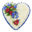 This photograph presents a refined, heart-shaped floral tribute, meticulously crafted for a funeral or memorial, the kind of piece one might see lovingly delivered to a Stanmore chapel or cemetery. The heart is entirely covered with small, tight white chrysanthemum blooms, each floret carefully nestled beside the next to create a dense, cushion-like surface. The soft, rounded petals form a uniform texture, giving the impression of a gentle, cloud-like bed of white that symbolises peace and purity. Encircling this bed of chrysanthemums is a royal blue satin ribbon, pleated into delicate ruffles that follow the contours of the heart and lend a formal, almost regimental feel. The ribbon's glossy surface catches the light, adding depth and structure to the outline. In the upper left portion of the heart, a striking floral spray becomes the central focal point. Three deep red roses, all fully open, display velvety, layered petals that spiral inward to rich, dark centres, framed by dark, glossy foliage. Cascading out from and beneath these roses are electric blue dendrobium orchid florets, their slender stems and star-like petals flowing diagonally across the white base, like a ribbon of colour sweeping through a quiet garden near Canons Park. Fine, curling green tendrils weave through the orchids, softening the lines and adding a touch of natural whimsy. Towards the lower right curve of the heart, a solitary red rose rests against the chrysanthemums, mirroring the roses above but offering a more intimate, personal gesture, as if from a single mourner. The overall design uses its palette of white, blue, and red to express purity, love, respect, and calm, making this floral heart a dignified and comforting symbol of farewell for Stanmore families.