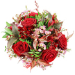 The image shows a full, rounded bouquet photographed from above, resting on a crisp white background that frames its rich, romantic colours. At its heart, deep crimson red roses are artfully clustered, their velvety petals spiralling outwards in classic, layered whorls that convey warmth and passion. Some roses are wide open and confident, others more tightly furled, lending the arrangement a sense of gentle movement, as though it were breathing. Threaded among the roses are delicate sprays of pale pink waxflower, each tiny, star-shaped blossom with a soft yellow centre adding a cloud of light, intricate texture that offsets the intensity of the larger blooms. A lush bed of green foliage surrounds and supports the flowers, ranging from wide, glossy leaves to slimmer, textured sprigs that recall the varied greenery seen in the gardens and verges of Stanmore's quiet residential roads. Woven through the greens are distinctive accent leaves in deep burgundy and bronzed tones, some lined with reddish-brown veins, which add sophistication and a faintly autumnal mood, like the late-season colours visible around Bentley Priory. Dotted throughout are smaller, darker red flowers, perhaps alstroemeria, adding further depth to the crimson palette and drawing the eye into the finer details of the design. At the lower edge of the bouquet, a glimpse of red and white patterned tag or ribbon suggests a message or dedication, ready to be delivered to a loved one near Stanmore station or a family celebration along The Broadway. Crafted with the skill and sensitivity of Flowers Stanmore, this arrangement feels luxurious yet intimate, ideal for anniversaries, romantic gestures, or any special occasion where heartfelt emotion needs to be expressed with flowers.