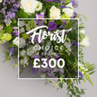 In a softly lit studio setting against a pale grey backdrop, Flowers Stanmore presents a luxurious Florist CHOICE SPRAY. The arrangement unfolds as a generous, nearly opulent bloom cascade, designed to offer a sense of pageantry and heartfelt tribute. Ivory white roses stand at the heart, their velvety petals speaking of timeless elegance and consoling grace. Surrounding them, white lisianthus unfurl in delicate, ruffled layers, while slender white freesias lend a crisp, airy note that midair-sways with every breath of the room. Rich purple accents rise through the spray: deep purple lisianthus, softer lavender-e hued eustoma, and, here and there, purple freesias that add unexpected, regal flashes of colour. Tall, spiky elements of veronica or delphinium punctuate the design, drawing the eye upward and giving the spray a stately height. Interwoven lavender limonium threads contribute subtle texture and a sense of quiet movement, as do the verdant fronds and glossy leaves that form a lush green frame around the bouquet. Light green viburnum-like clusters punctuate the arrangement with a fresh, restorative hue, balancing the purples with a gentle vitality. A pristine white rectangular overlay sits at the center, bearing Florist CHOICE SPRAY in elegant white typography, with Florist scripted in a flowing hand and CHOICE SPRAY in bold uppercase, followed by the bold, white price ?300. This image radiates premium craftsmanship and emotional warmth, ideal for solemn sympathy tributes or grand celebrations of life, and it is presented as a ready-to-order option with same-day delivery across Stanmore, Canons Park, and the surrounding NW London areas, reflecting our local expertise and freshness.